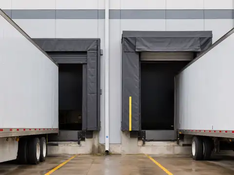 Warehouse loading docks showing dock seal and dock shelter configurations around trailers
