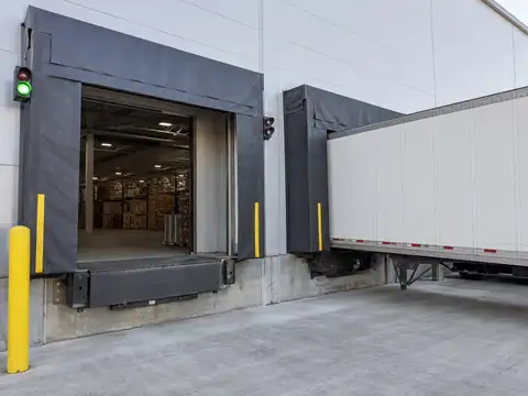 Modern warehouse loading dock with dock levelers, shelters, trailers and safety equipment