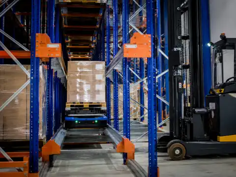 Automated pallet shuttle operating inside high-density warehouse racking