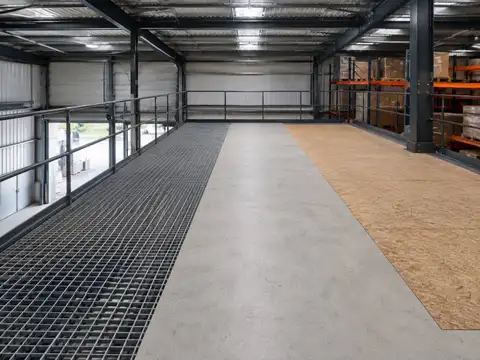 Warehouse mezzanine construction project with structural steel, access equipment and installation work in progress